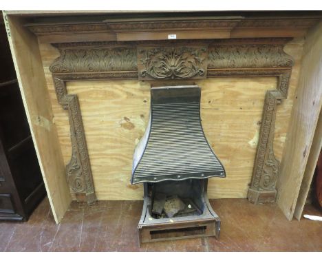 An antique pine Fire Surround having breakfront mantelpiece and carved acanthus leaf frieze, 5ft 8in wide, together with cast