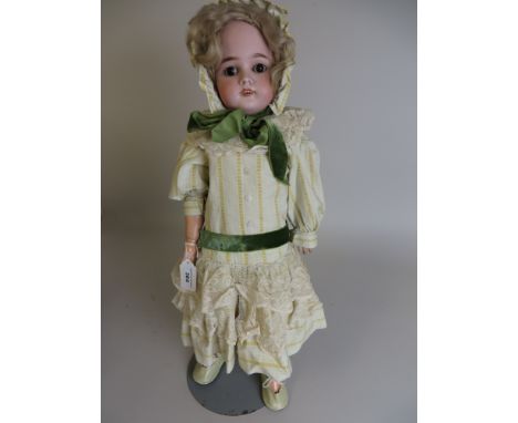 A Heinrich Handwerck  bisque headed Doll with pierced ears, brown sleeping eyes and heavy brows. Original wig and fully joint