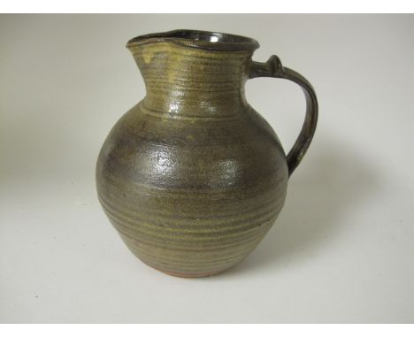A Michael Cardew, Winchcombe pottery baluster Jug with brown and yellow treacle glaze, pinched pouring spout with scroll hand