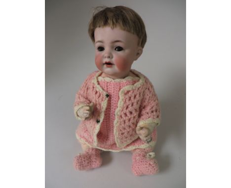 A Kammer & Reinhardt character Doll with bisque head and sleeping eyes. Original wig and pink crochet costume. Impressed K&R 
