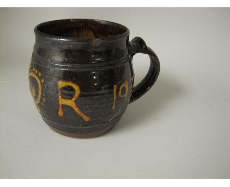 A Michael Cardew, Winchcombe pottery Tankard of barrel shape with brown glaze and cream title G.R. with crown 1910-1931, 5in 