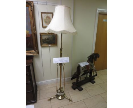 An Art Nouveau brass telescopic Standard Lamp and Shade on three stylised leafage feet