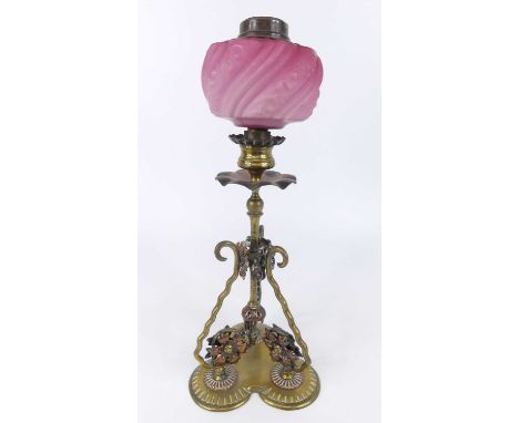 Attributed to W.A.S. Benson - an Arts &amp; Crafts copper and brass oil lamp, having a pink moulded glass reservoir, raised o
