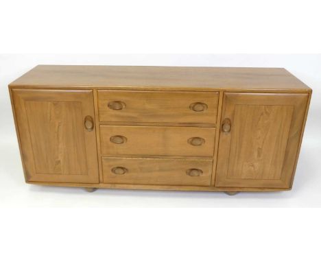 An Ercol blond elm Windsor sideboard, model No. 455, having three central drawers flanked by cupboard doors, each with integr