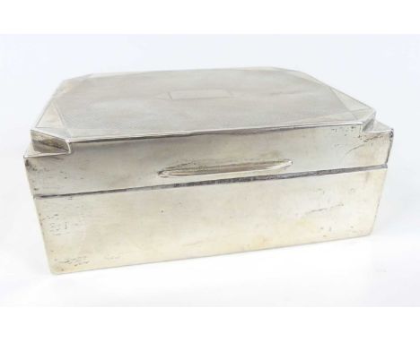 An Art Deco silver table cigarette box, having engine turned hinged cover, chamfered corner detail, and with cedar lined inte