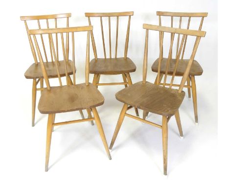 A set of five 1960s Ercol blond elm stickback kitchen chairs, model No. 391, raised on turned and slightly tapering supports,
