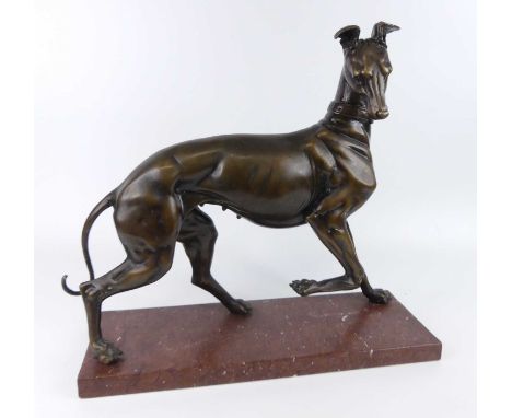 A large Art Deco style bronzed metal model of a standing greyhound, its front right raised and with head turned, mixed brown 