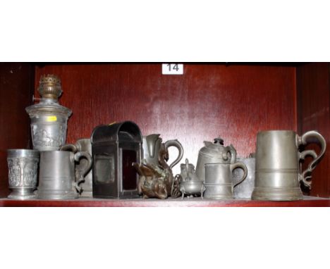 A pewter oil lamp, decorated classical scenes, various pewter tankards, jugs and other items