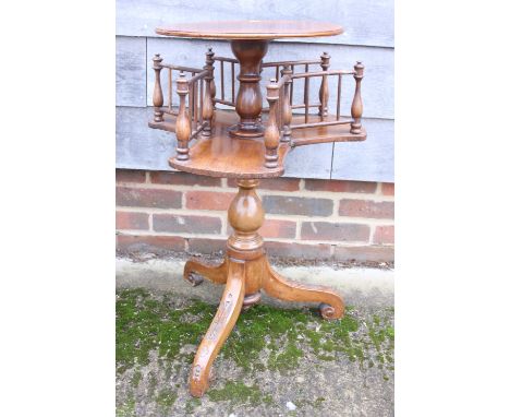 A Victorian walnut circular revolving library table, on tripod splayed carved supports, 14" dia