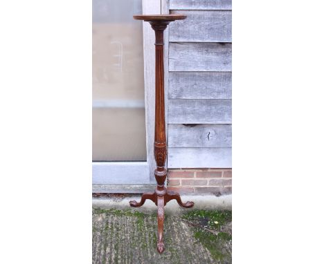An early 20th century mahogany torchere stand with concave column, acanthus carved base, on tripod ball and claw supports
