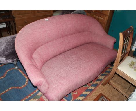 A two-seat sofa, upholstered in a red fabric, on ebonised supports, 63 1/2" wide and a footstool, upholstered in a grey fabri