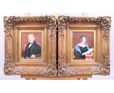 A 19th century miniature portrait on ivory of a seated gentleman, in ornate gilt frame, and a companion female painting on iv