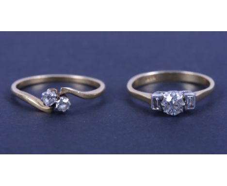 A yellow metal diamond ring with central circular diamond flanked by two baguette cut diamonds, stamped 18ct, size K/L, and a