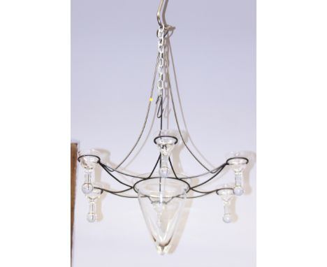 A wrought iron six-light chandelier with glass candle holders