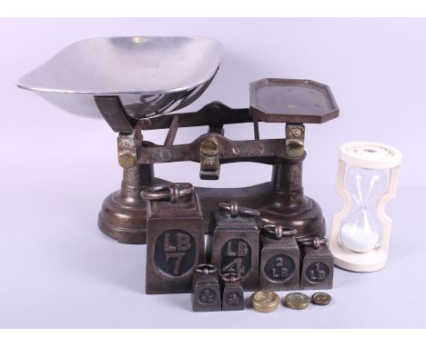 A cast iron kitchen balance, nine weights and a cast iron four-minute egg timer