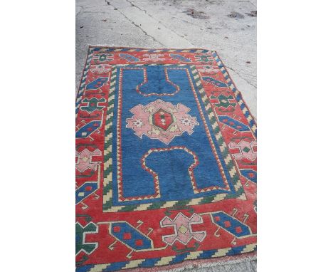 A Turkey carpet with central geometric medallion on a blue ground and hooked guls to the borders, 108" x 70" approx