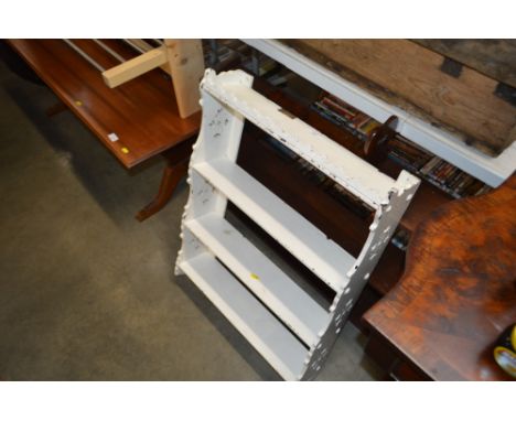 A white painted wall shelf; extending book rack; and a set of mahogany shelves