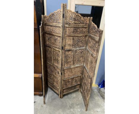 An Indian carved hardwood four fold screen, largest panel width 50cm, height 184cm