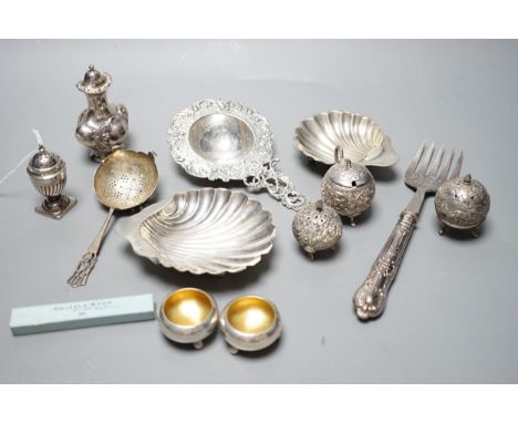 Small silver including two butter shells, a continental silver tea strainer, English tea strainer, pair of salts, swizzle sti