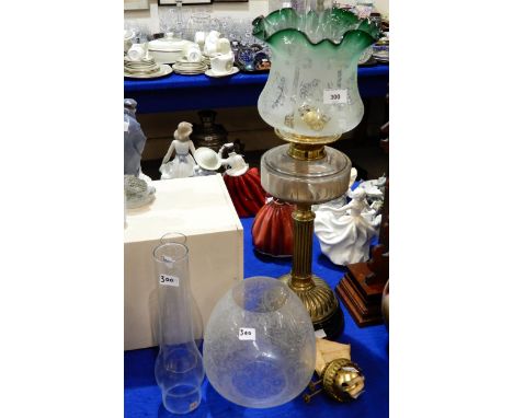 A Victorian brass oil lamp with green edged etched glass shade, another shade and funnels together with an American gingerbre