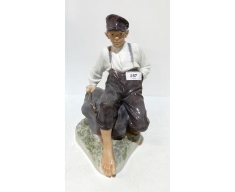 A large Royal Copenhagen figure of a seated boy on a rock holding a fishing rod, designed&nbsp;by Christian Thomsen,&nbsp; mo