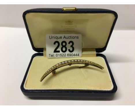An unmarked gold and seed pearl crescent moon brooch