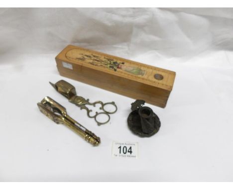 A brass nutcracker with portrait of William Shakespeare, a brass candle snuffer, a miniature candlestick and a wooden pencil 