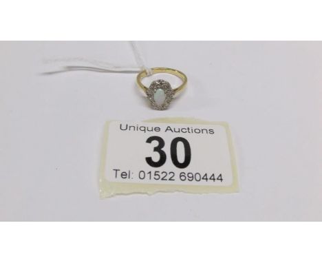 An 18ct gold ring set with opal and diamond chips, size M