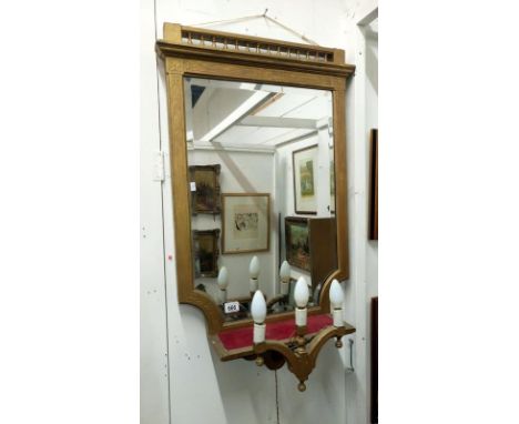 A gilded wall mirror with attached lights
