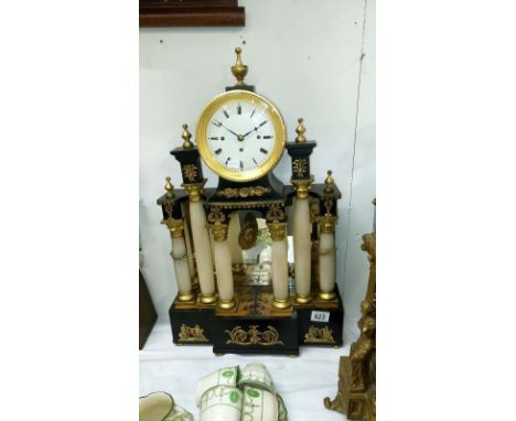 A ornate mantel clock with columns