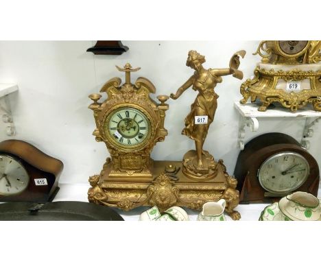 A gilded mantel clock surmounted figure