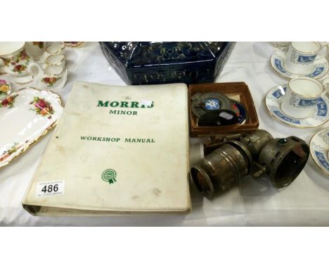 An RAC badge, and IPA badge, a bike lamp and a Morris Minor workshop manual