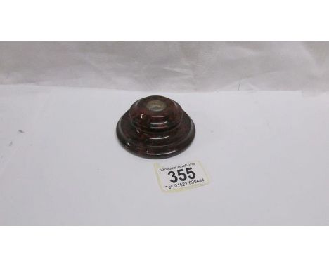 A small compass set in a red Cornish serpentine base