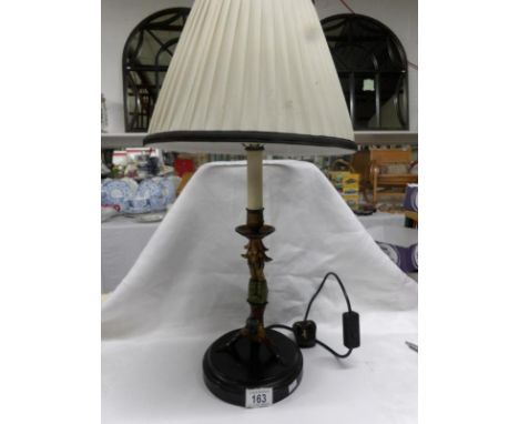 A table lamp being a figure of an Indian doing a handstand, complete with shade