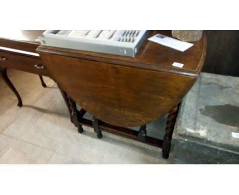 A medium sized oak gate leg table on barley twist legs