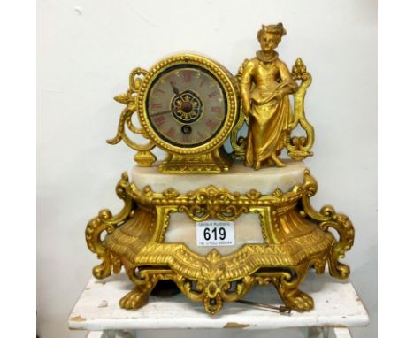 A gilt mantel clock surmounted figure