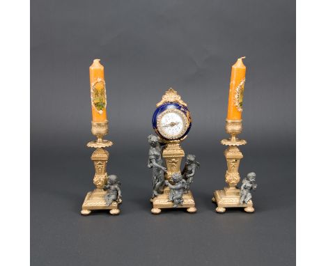 French clock set, comprising two candle sticks and one clock, each on canted columns, with rich figural and ornamental decora