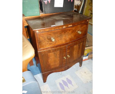 A bow fronted Mahogany Bedside Table having a frieze drawer and cross-banded double doored cupboard below and standing on sha