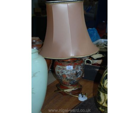 A ceramic oriental table lamp with a blush pink shade.