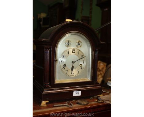 A Junghans of Wurtenberg dark Mahogany arched cased Bracket Clock having reeded pillars flanking a polished steel face with A