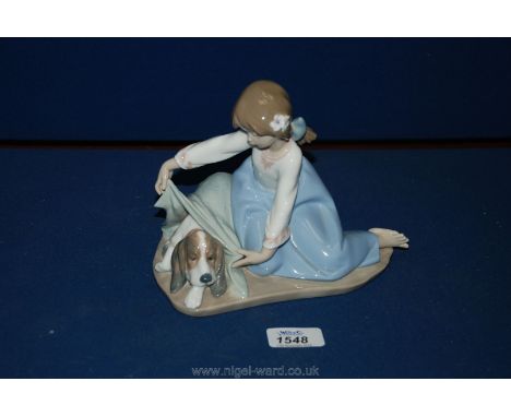 A Lladro figure of a girl and her dog under a blanket.
