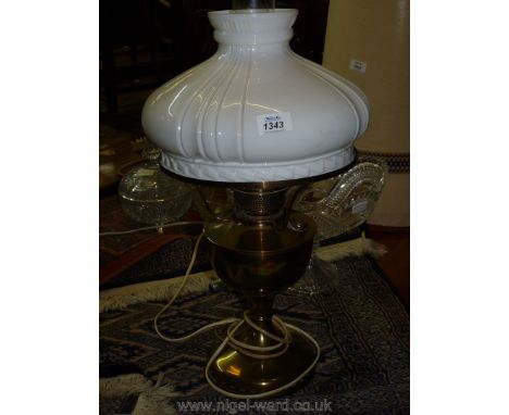 A brass oil lamp with a white glass shade, converted to electric.