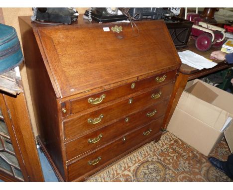 A Georgian Mahogany Bureau, the fall front revealing a nicely fitted interior with pigeon holes and drawers, a central geomet