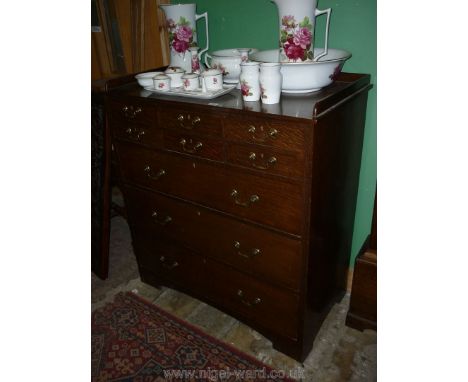 A 20th c. Oak Chest of three long and six short Drawers, having brass swan-neck handles, standing on bracket feet and with lo