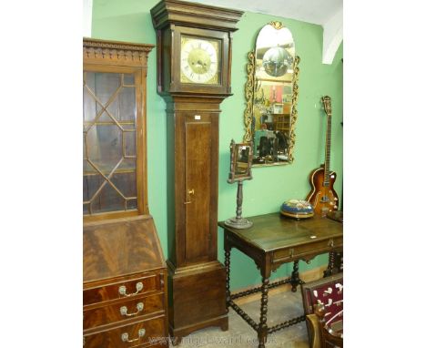 An Oak Longcase Clock having a square brass face with cast spandrels and silvered chapter ring with Roman numerals and Arabic