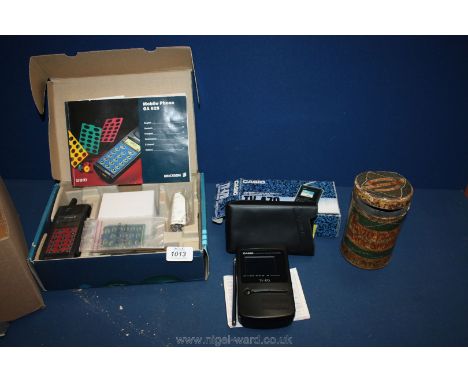 A vintage Ericsson mobile phone, Casio mini LCD colour TV 2.2" screen and an old Huntley and Palmer shortbread tin.