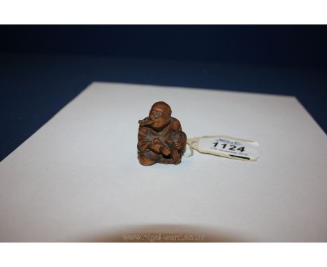 A Japanese wood Netsuke, 19th c. depicting man smoking a pipe.