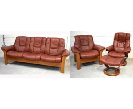 A Stressless wooden framed burgundy leather upholstered suite comprising a reclining three seater sofa, approx 210cm, a match