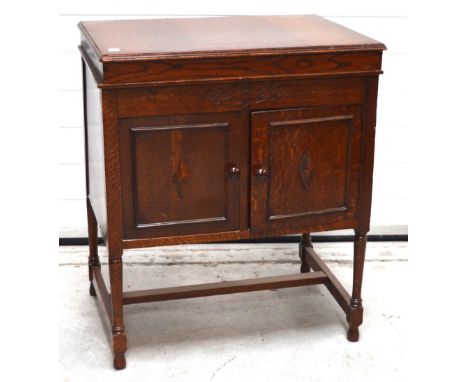 An oak 'The Vocalist Supreme' gramophone cabinet supplied by Frederick Victor Ltd of Haymarket Liverpool, twin doors with spe