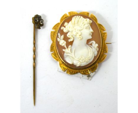 A cameo brooch in a 9ct gold mount and a yellow metal stick pin with shamrock finial set with white stones (2).